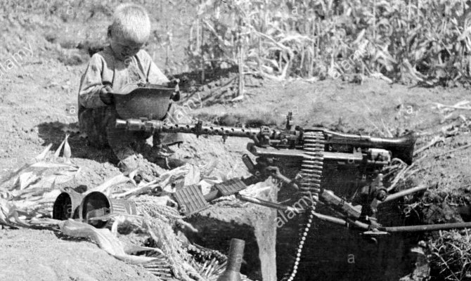 boy-examines-abandoned-german-weapons.jpg
