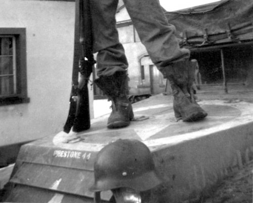 A US standing on a tank and holding a liberated bottle of wine and a German helmet-2.JPG