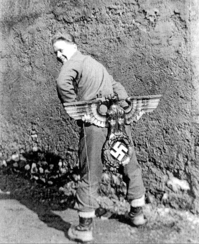 Red Stegman, looking over his shoulder while holding a Nazi emblem behind his back. .jpg